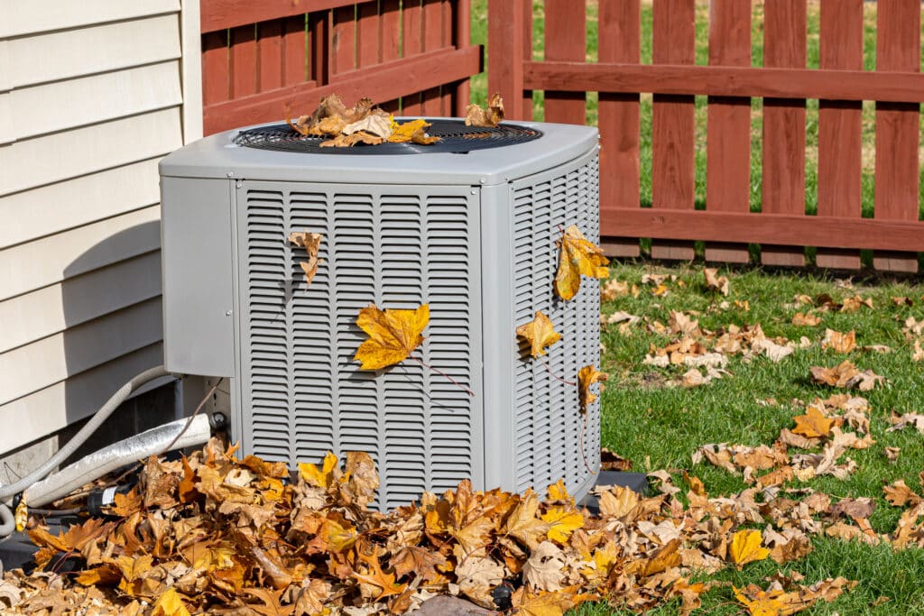 Ohio residential outdoor HVAC unit in the fall covered in leaves